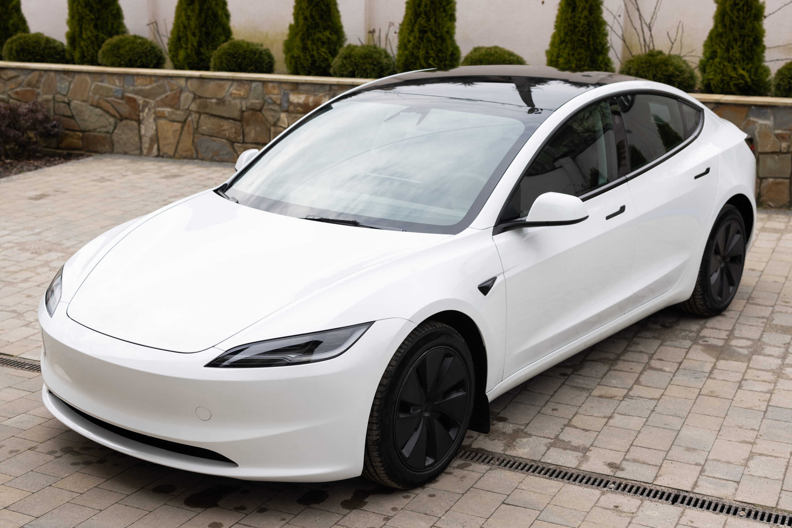 White electric sedan car standing in a road. Fleet of generic modern electric cars. Transportation. Luxury car fleet. Luxury hybrid white car.
